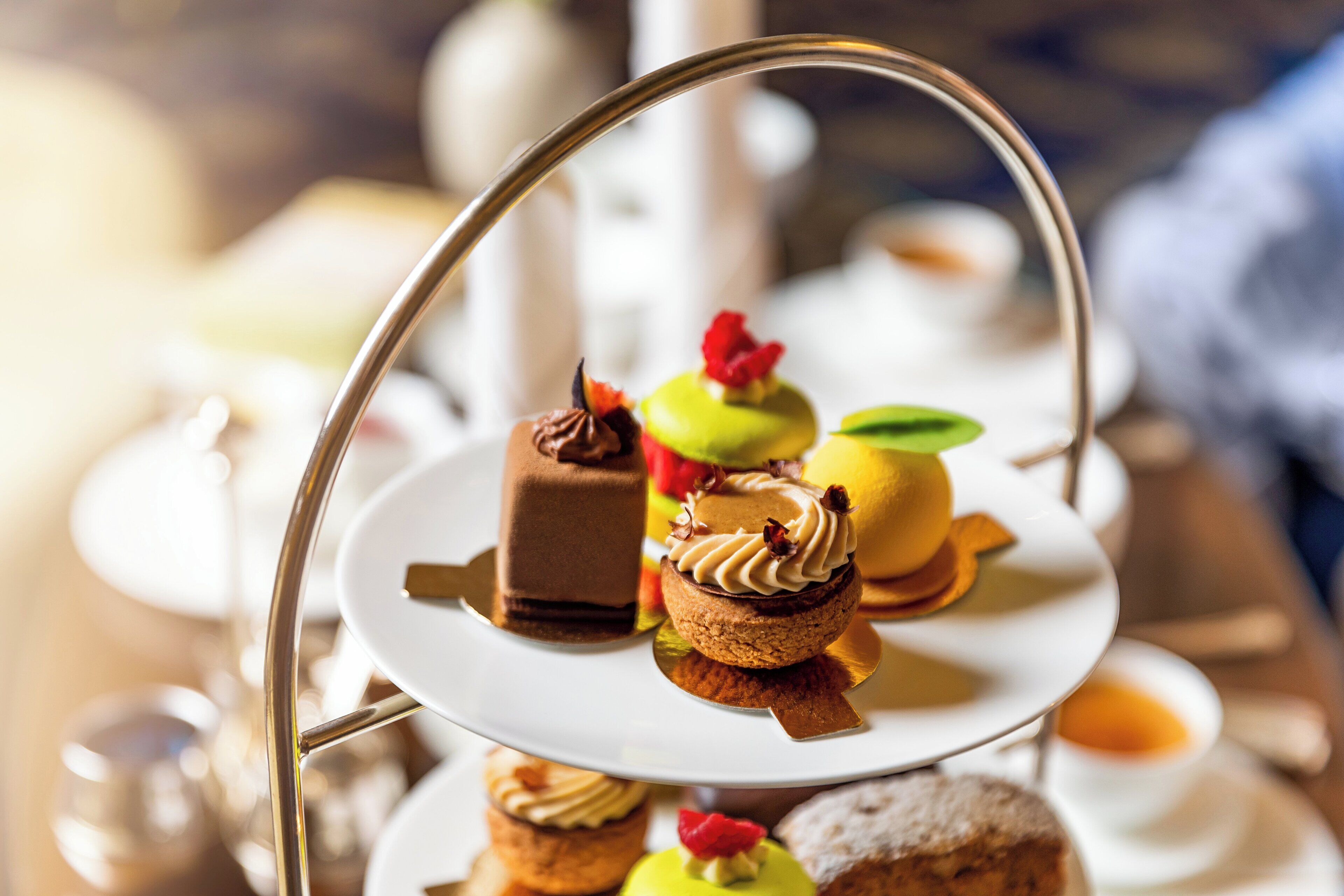 Een drielaagse presentatietafel met diverse gebakjes en desserts.