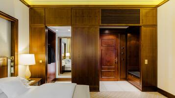 A hotel room with a large bed, wooden wardrobe, and a mirror.