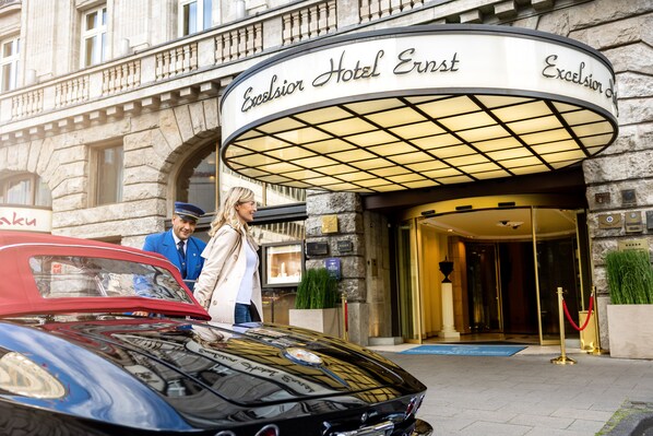 L’entrée de l’hôtel Excelsior Ernst, avec une voiture d’époque garée devant.