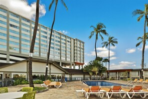 A hotel with a swimming pool, lounge chairs, palm trees, and a multi-story building. - Best Western The Plaza Hotel Honolulu Airport - Free Breakfast (Honolulu)