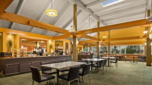 A spacious indoor area with a high ceiling, a central bar area, and multiple seating arrangements.