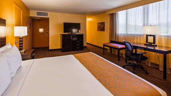 A hotel room with a large bed, a desk with a chair, a television, and a window with curtains. - Best Western The Plaza Hotel Honolulu Airport - Free Breakfast (Honolulu)