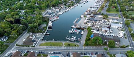 Vue aérienne d’une marina avec de nombreux quais, des bateaux et un espace de stationnement.