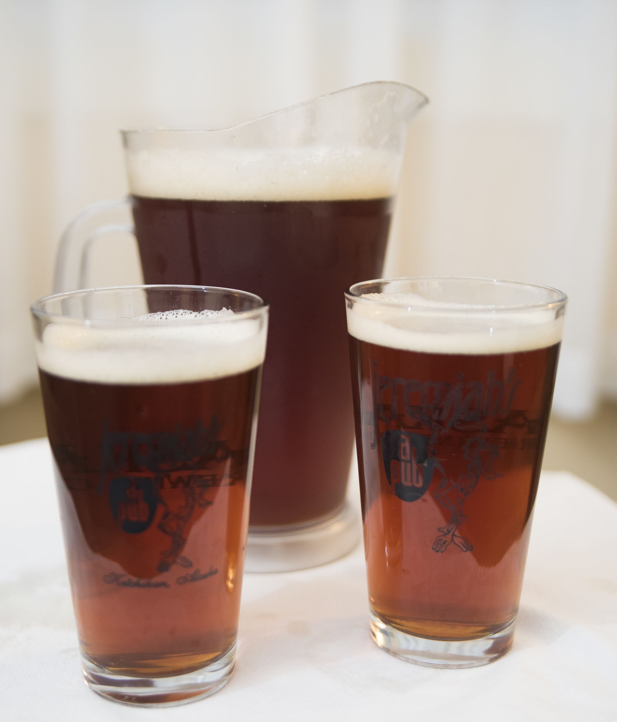 Duas cervejas e um jarro sobre a mesa.