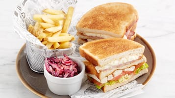 Ein Tablett mit einem gegrillten Sandwich, Pommes Frites und Krautsalat.