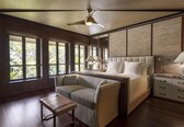 A spacious bedroom with a large bed, a sofa, a small table, and a nightstand.
