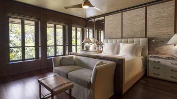 A spacious bedroom with a large bed, a sofa, a small table, and a nightstand.
