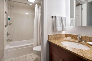 A bathroom with a bathtub, toilet, sink, and a mirror.