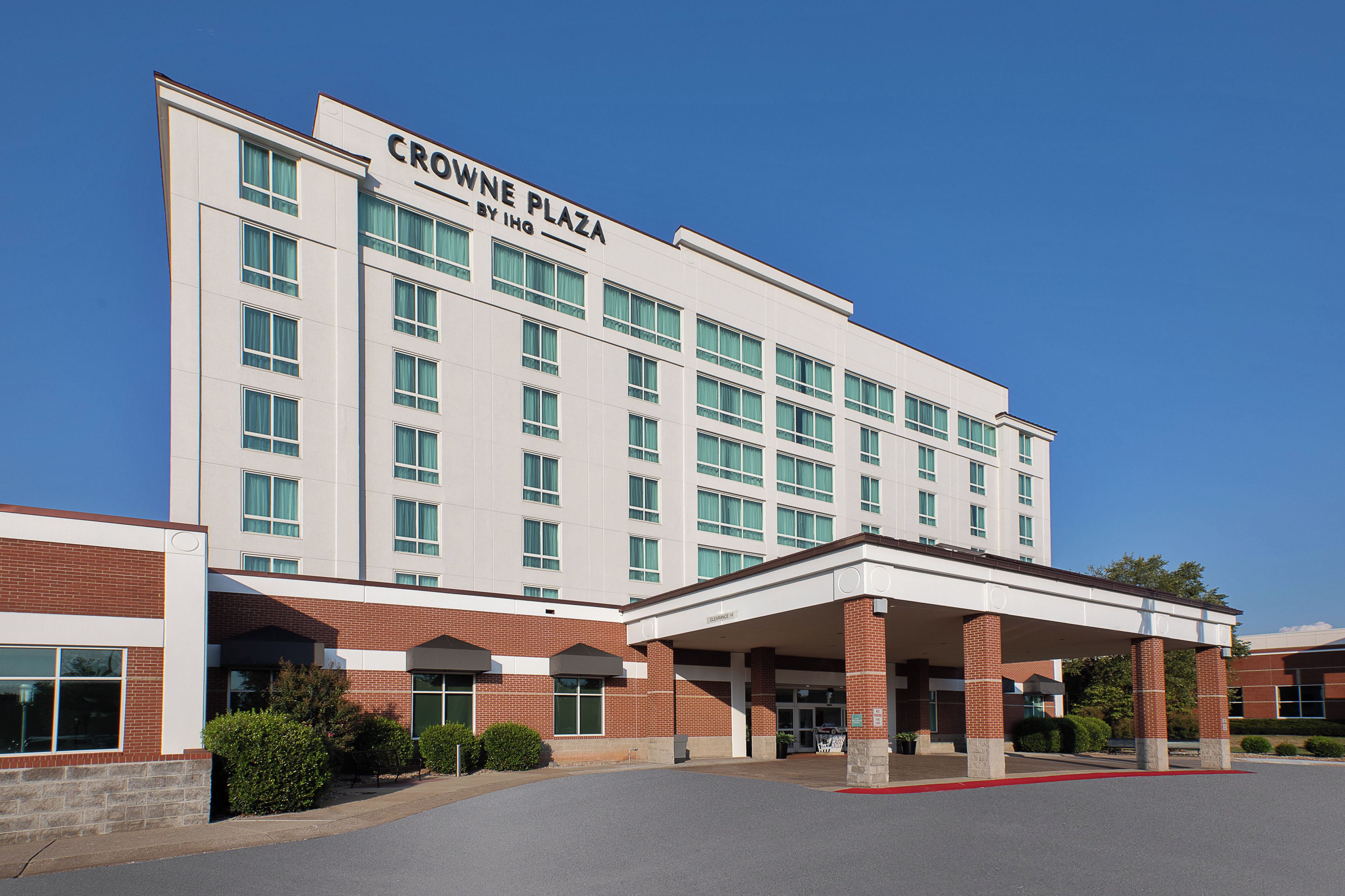 A multi-story hotel with a prominent sign reading 'CROWNE PLAZA BY IHG.'