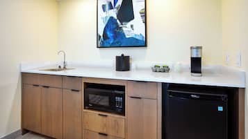 A modern kitchen with a built-in dishwasher, microwave, and coffee maker.