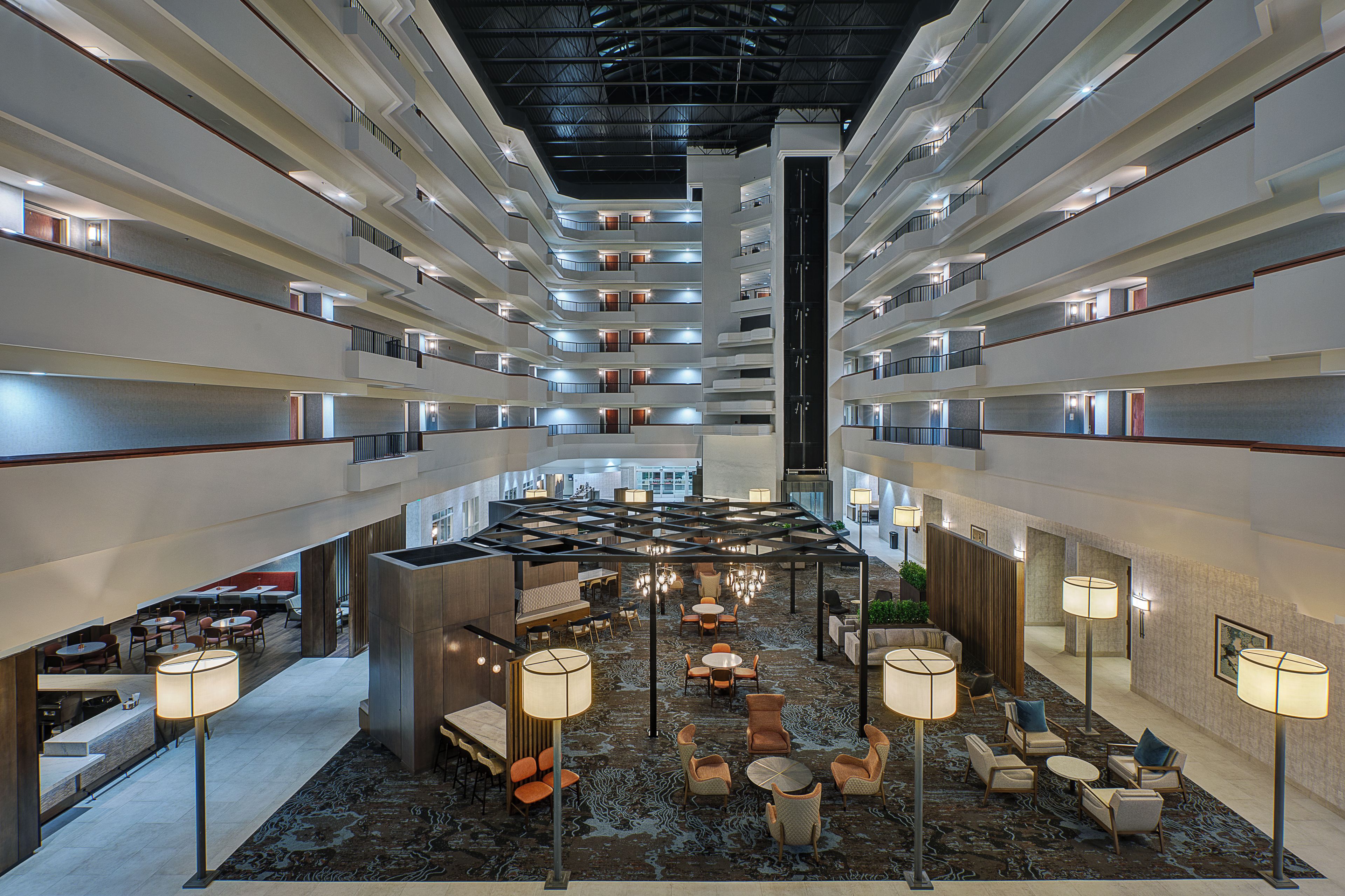 A multi-level hotel lobby with a central atrium, multiple floors, and a variety of seating arrangements.