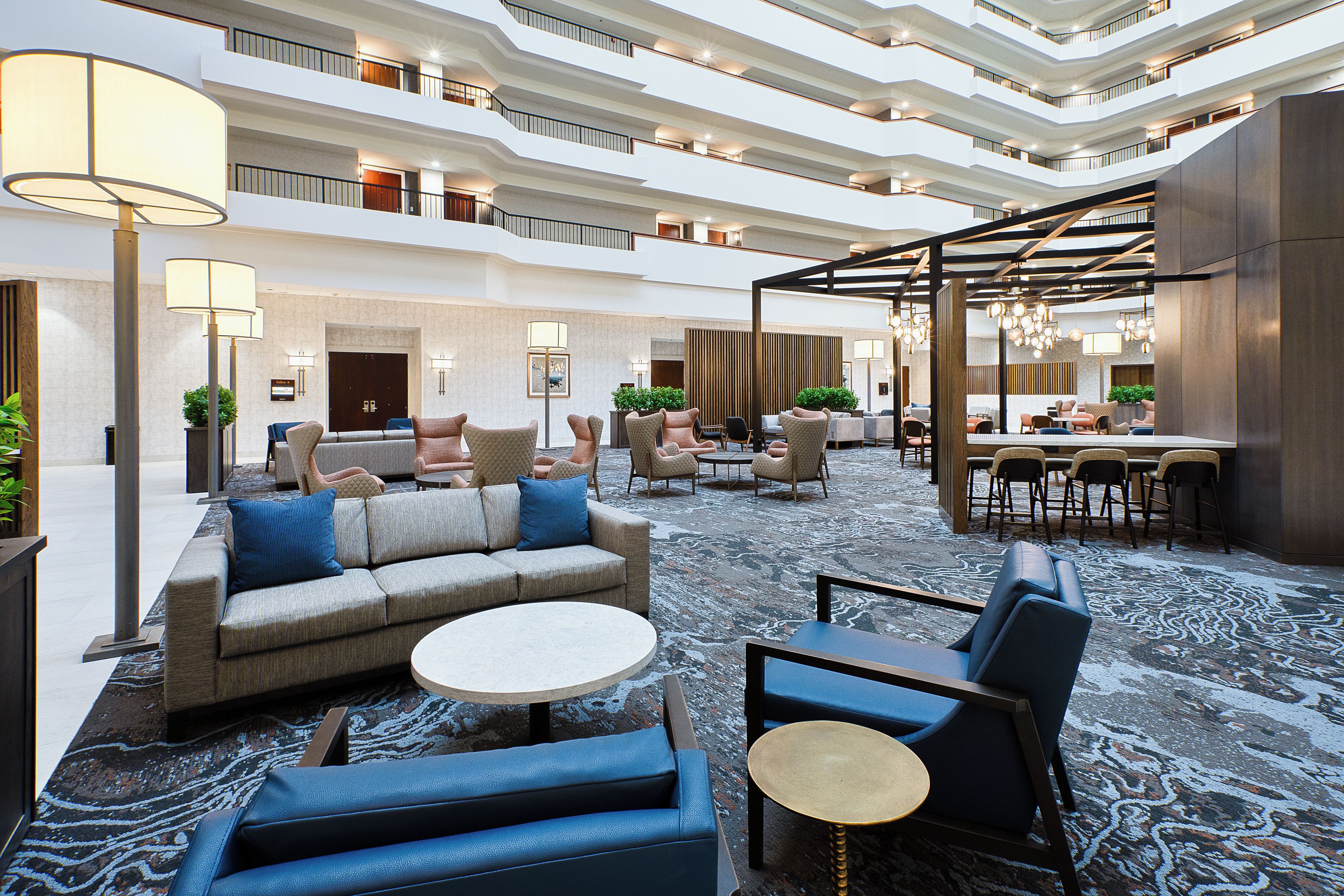 A spacious lobby with a central seating area, multiple levels of balconies, and a dining area.