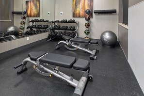 A gym with exercise equipment, including benches, dumbbells, and a ball. - Crowne Plaza Bowling Green KY by IHG (Bowling Green)