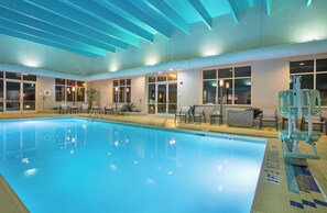An indoor swimming pool with clear water, surrounded by lounge chairs and a lifeguard stand. - Crowne Plaza Bowling Green KY by IHG (Bowling Green)