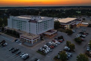 A multi-story hotel with a parking lot and a view of the sunset. - Crowne Plaza Bowling Green KY by IHG (Bowling Green)