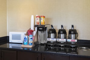 A kitchenette with a microwave, coffee maker, and coffee pots. - Red Roof Inn Cincinnati - Sharonville (Sharonville)