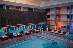 A pool area with lounge chairs and umbrellas, a high ceiling, and a multi-level building with balconies. - The Clarendon Hotel & Spa, BW Signature Collection (Phoenix)