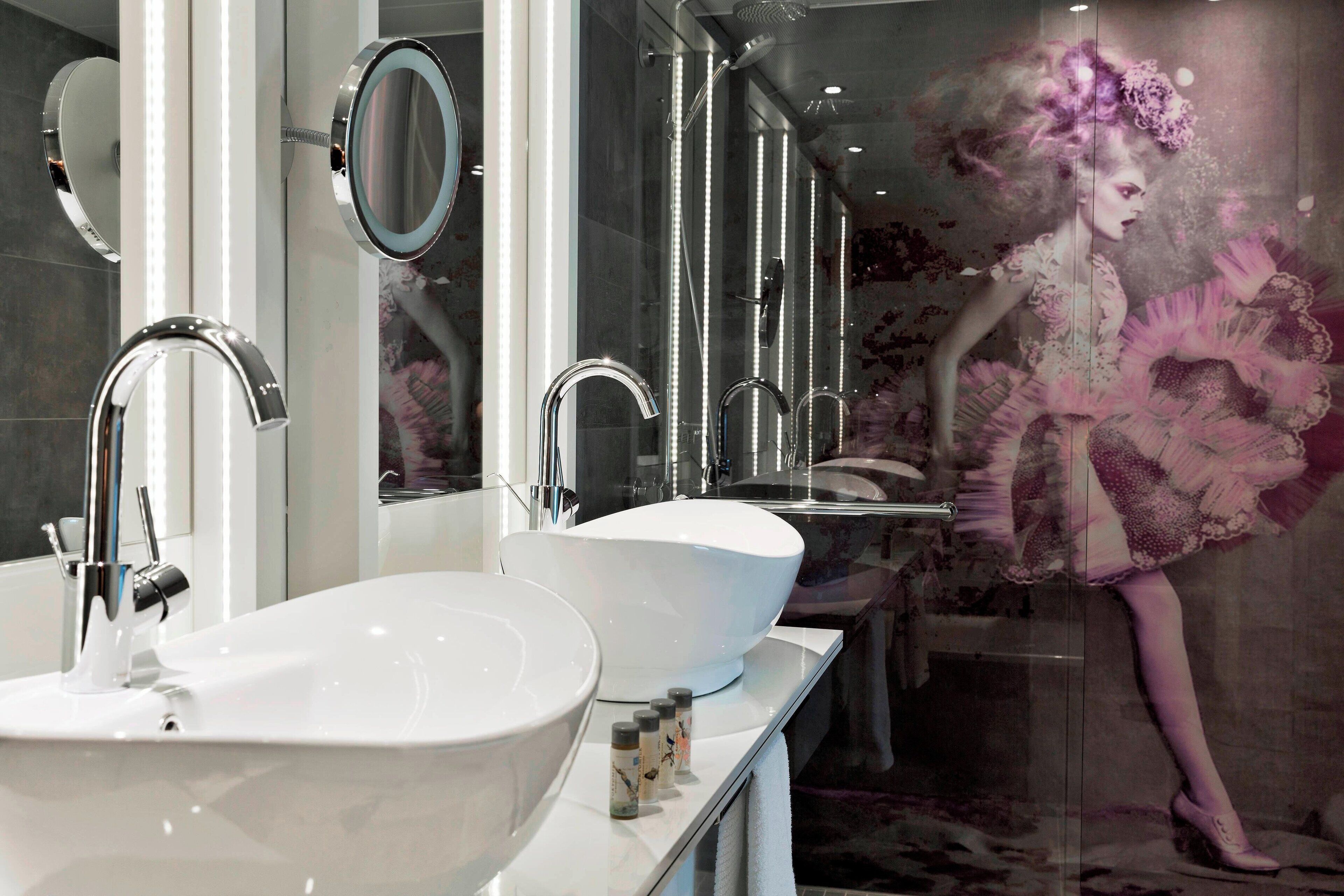 Ein modernes Badezimmer mit zwei Waschbecken, einem großen Spiegel und einer Duschkabine.