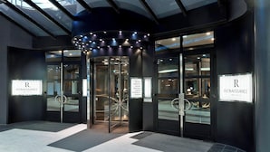 Entrada d'hotel amb portes de vidre, un torn i indicadors per 'Renaissance Wien Hotel'.