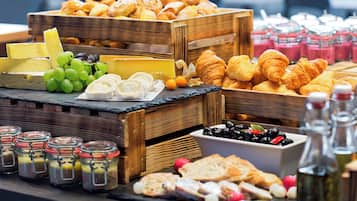 Diverse kazen, fruit en gebak gepresenteerd in houten kisten en potten.