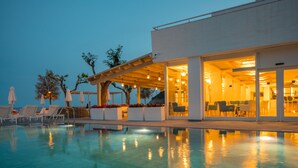 A modern poolside area with lounge chairs and a dining area. - Golden Mar Menuda (Tossa de Mar)