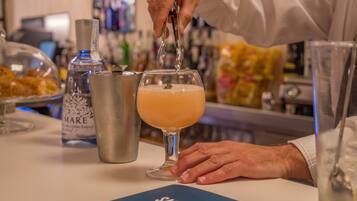 A bartender pouring a drink into a glass.