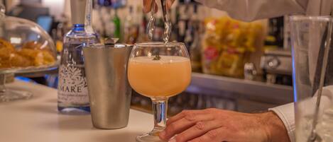 A bartender pouring a drink into a glass.