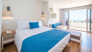 A modern hotel room with a large bed, a bedside phone, and a balcony with a view of the sea. - Golden Mar Menuda (Tossa de Mar)