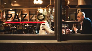A restaurant interior with a bar counter, seating, and a view of the street outside. - Kimpton Hotel Vintage Portland by IHG (Portland)