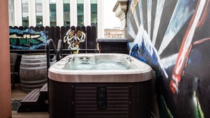 A hot tub in an outdoor area with a mural and a wooden barrel. - Kimpton Hotel Vintage Portland by IHG (Portland)