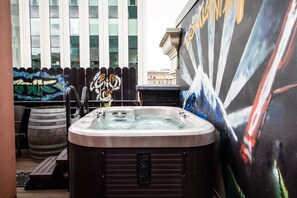 A hot tub in an outdoor area with a mural and a wooden barrel. - Kimpton Hotel Vintage Portland by IHG (Portland)