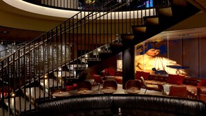 A modern interior with a curved staircase, leather seating, and a large mural. - Kimpton Hotel Vintage Portland by IHG (Portland)