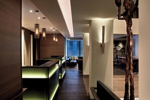 A modern interior with a reception desk, seating area, and a sculpture. - Kimpton Hotel Vintage Portland by IHG (Portland)