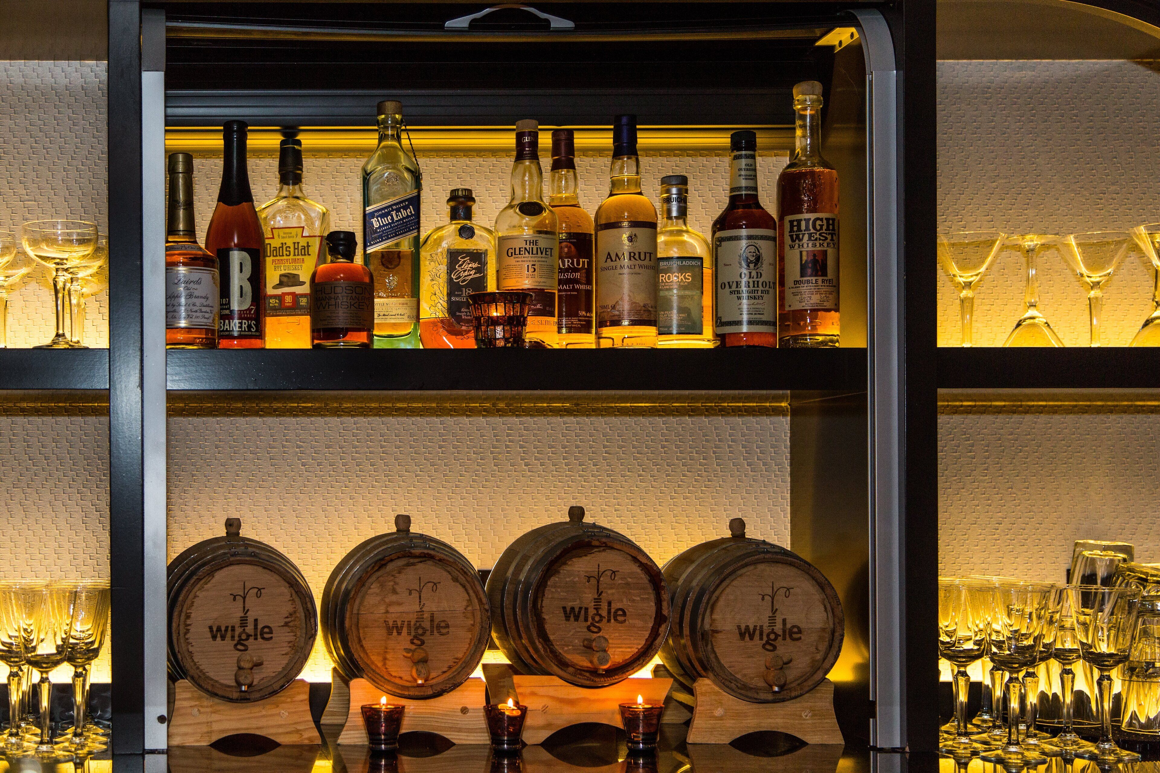 Una zona de bar con diversas botellas de licor y vasos.