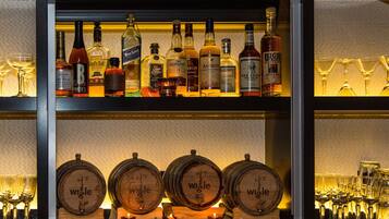 Una zona de bar con diversas botellas de licor y vasos.