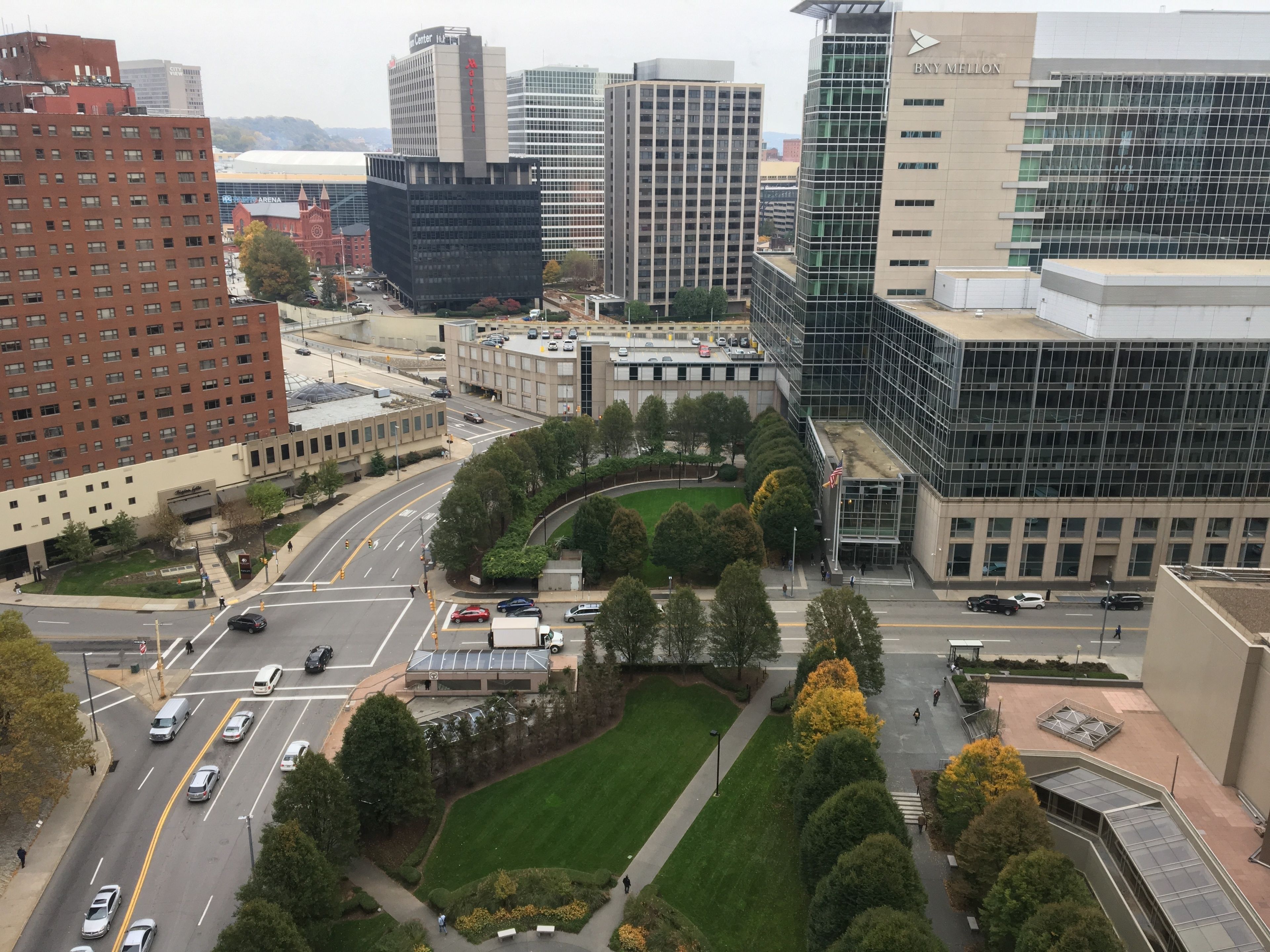 A cityscape with modern buildings, a central roundabout, and a well-maintained park area.