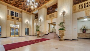A spacious lobby with a red carpet, ornate ceiling, and a staircase leading to upper floors. - Omni William Penn Hotel (Pittsburgh)
