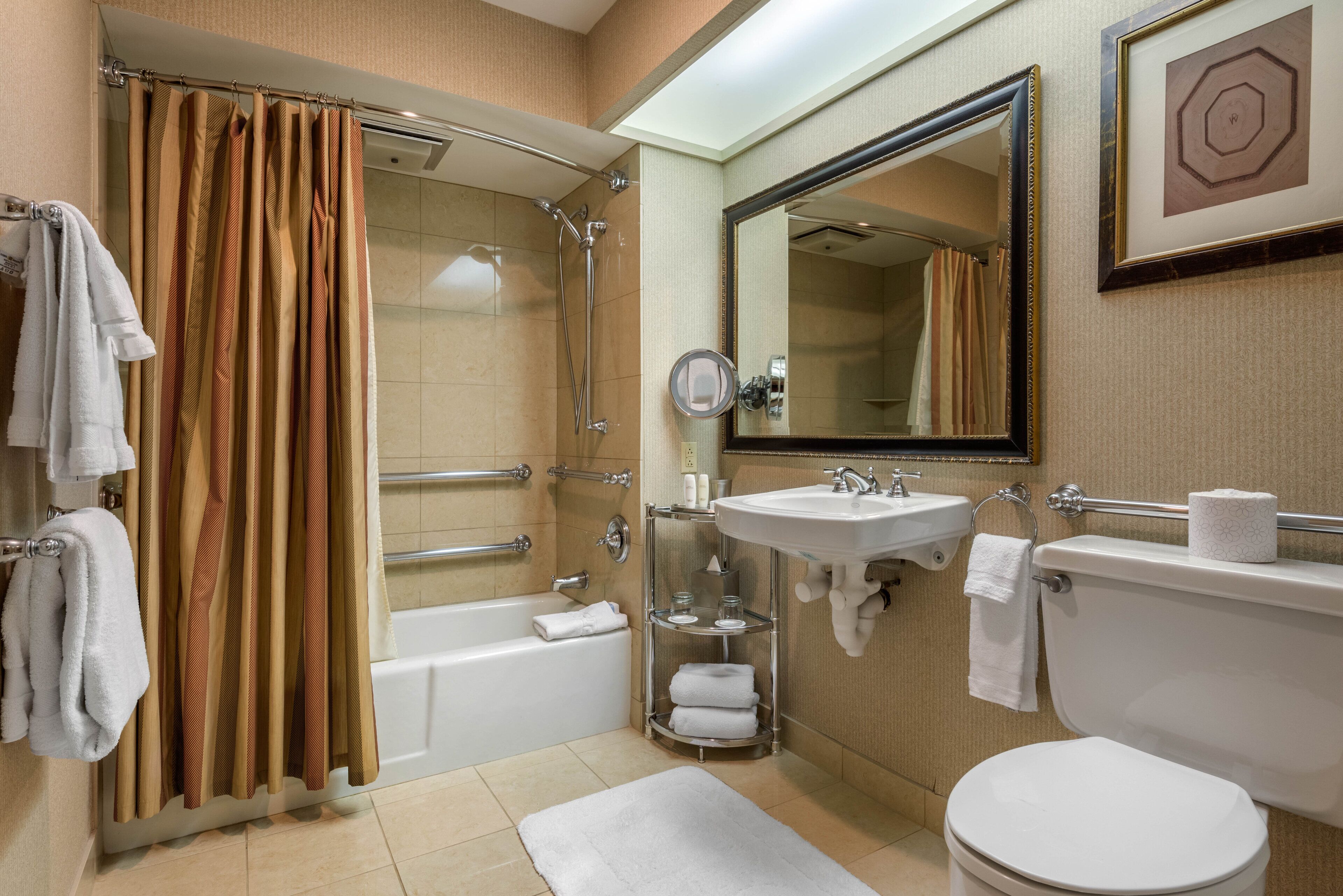 A bathroom with a bathtub, shower, toilet, sink, and a mirror.