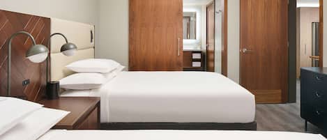 A hotel room with a bed, bedside tables, a lamp, a wardrobe, and a mirror.