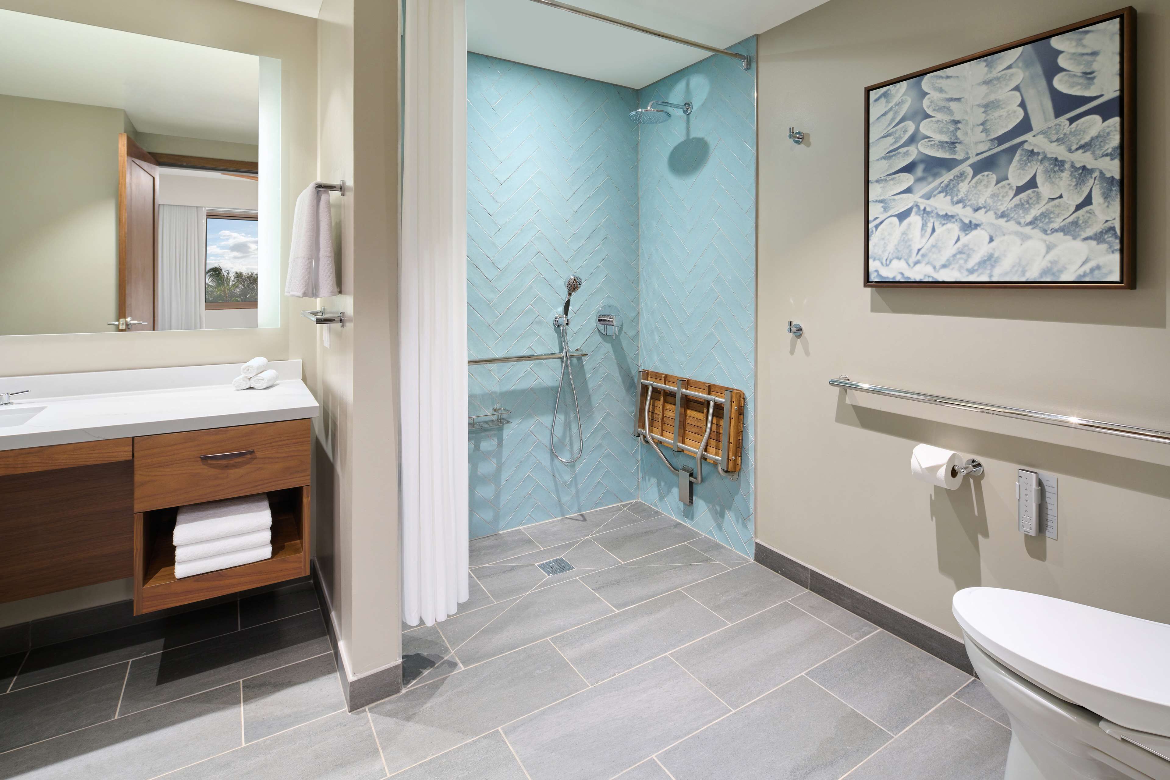 A modern bathroom with a shower, toilet, and vanity.