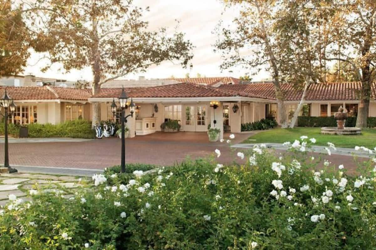 A hotel with a courtyard, a fountain, and a well-maintained garden.