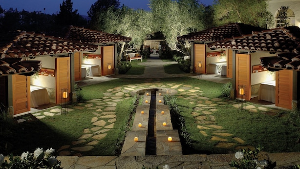 A courtyard with a stone pathway leading to two wooden cabins with tiled roofs. - Rancho Bernardo Inn (San Diego)