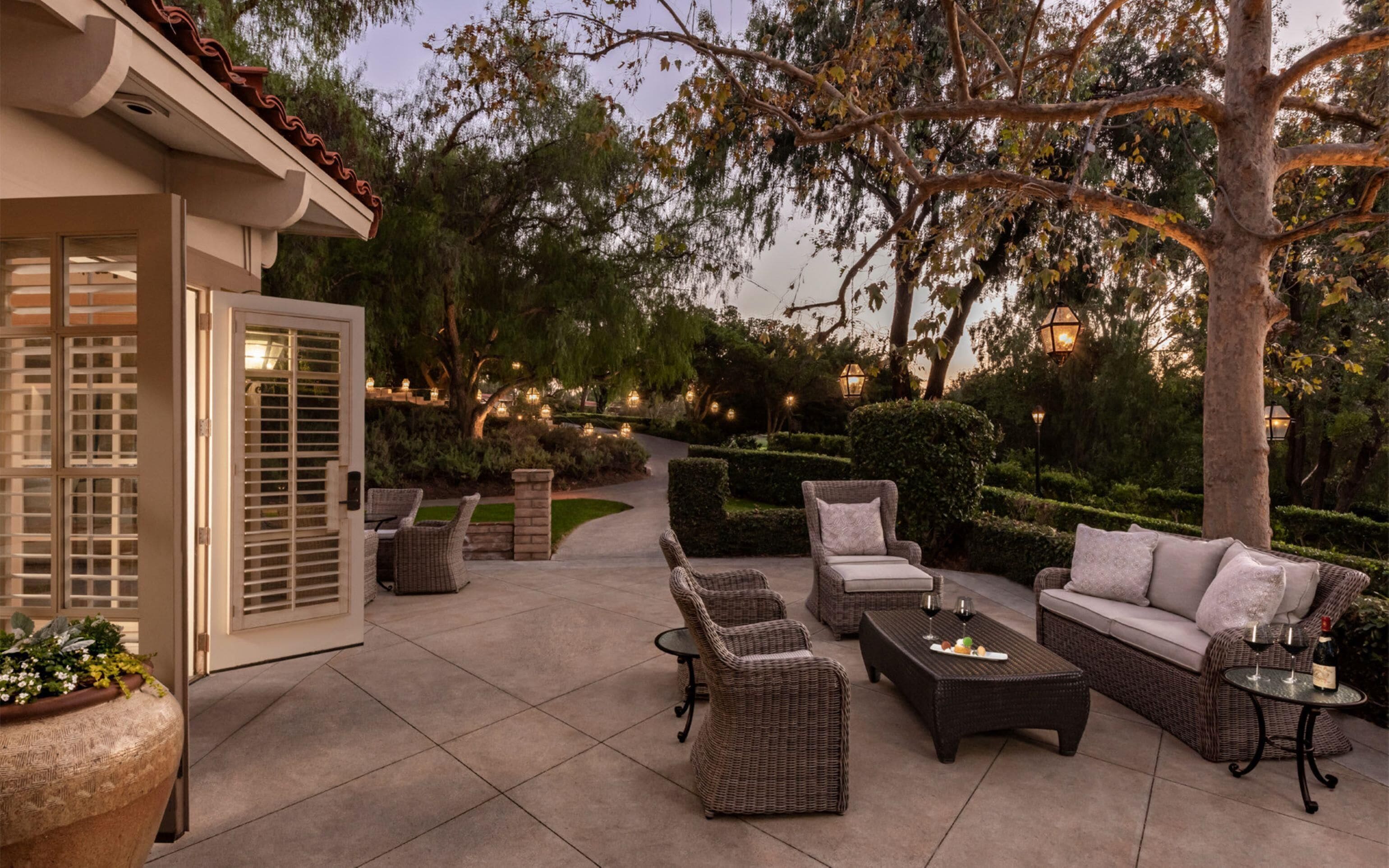 An outdoor patio with wicker furniture, a dining table, and a sofa.