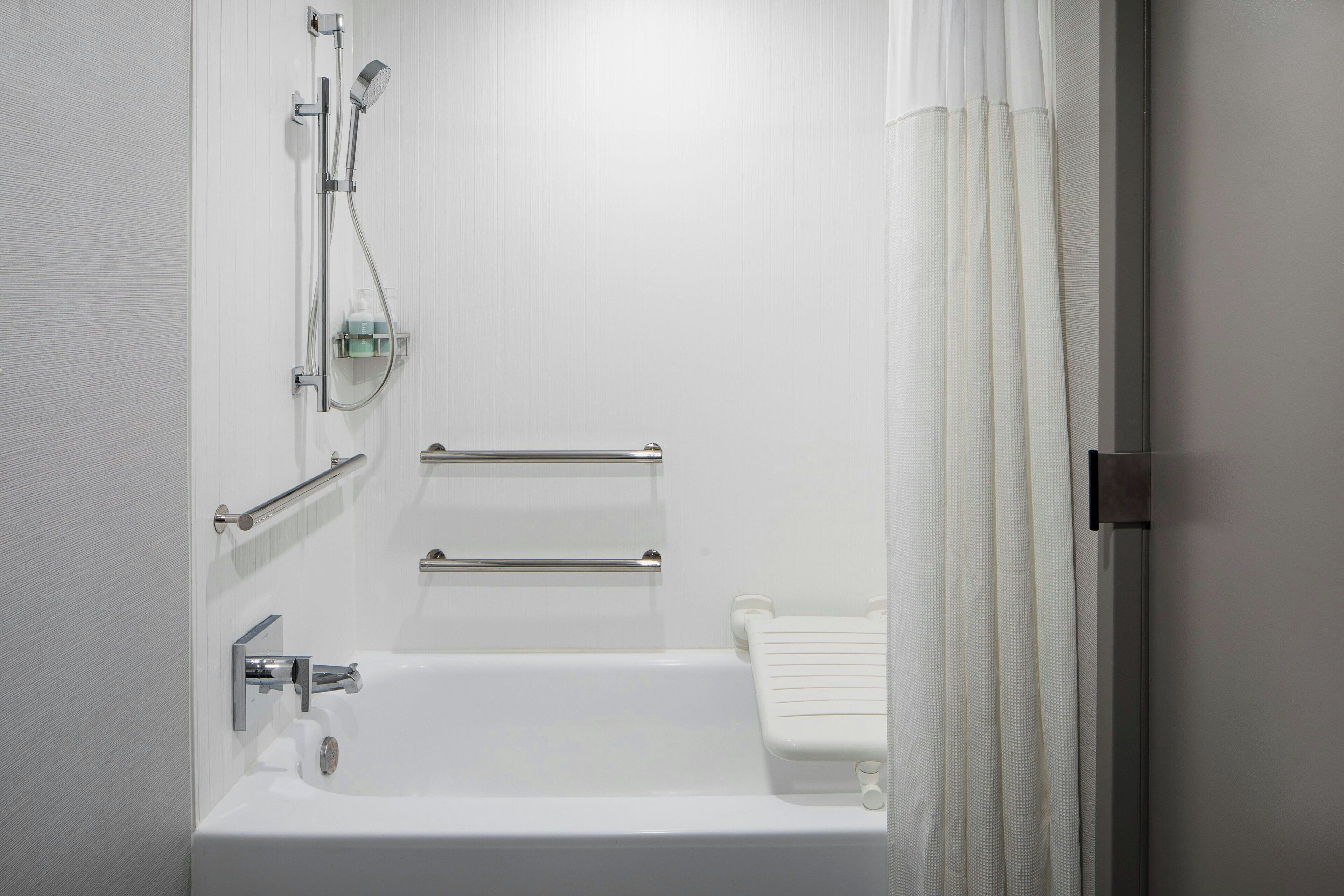 A modern bathroom with a bathtub, shower, and toilet.