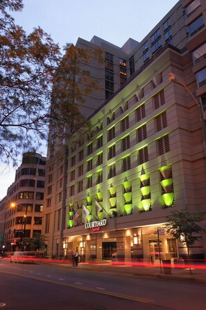 Un hotel de varios pisos con una fachada moderna, que presenta un llamativo letrero que dice 'Courtyard'.