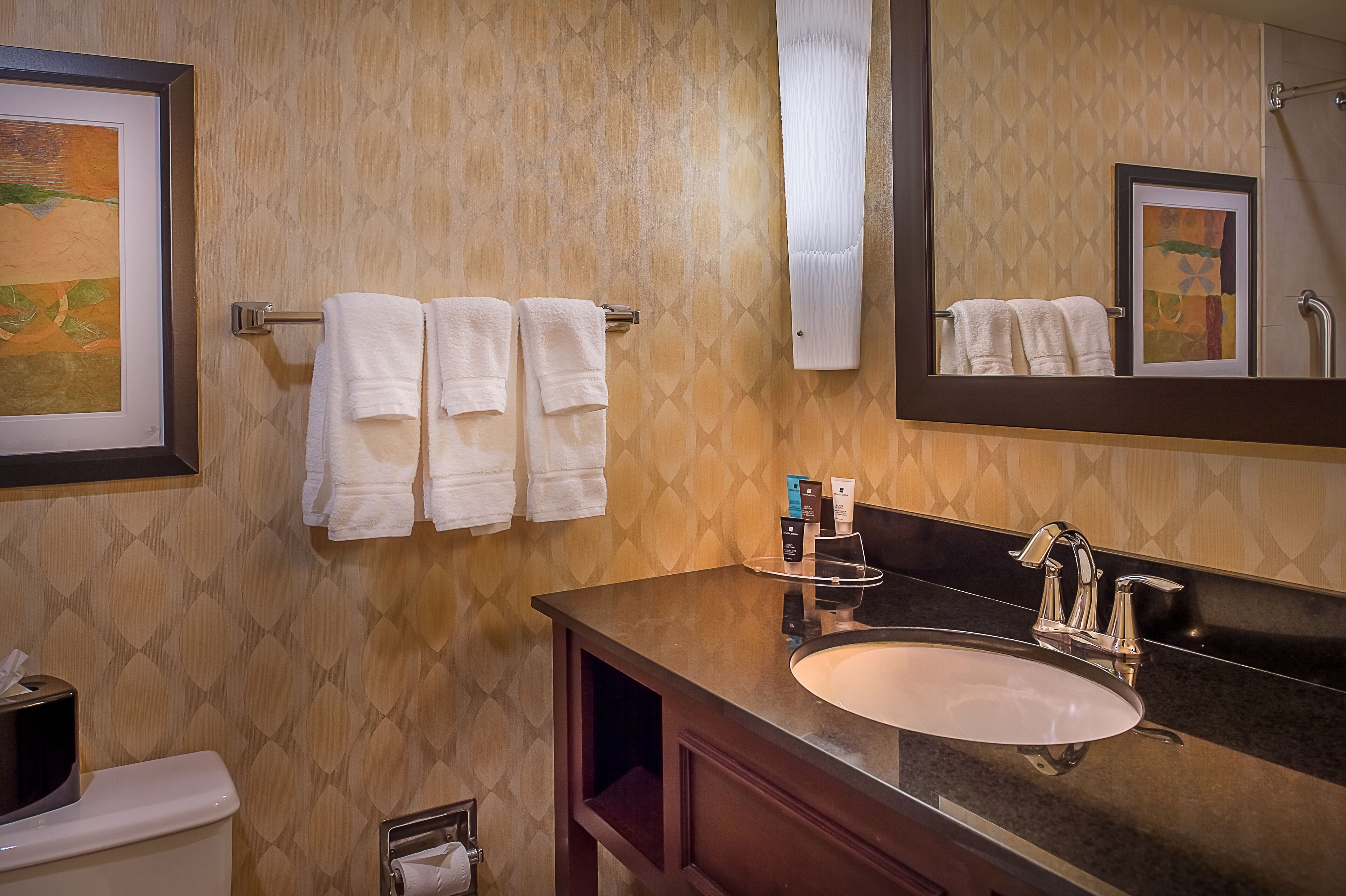 A bathroom with a sink, mirror, and towel rack.