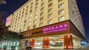Un hotel con una entrada destacada y señalización iluminada.