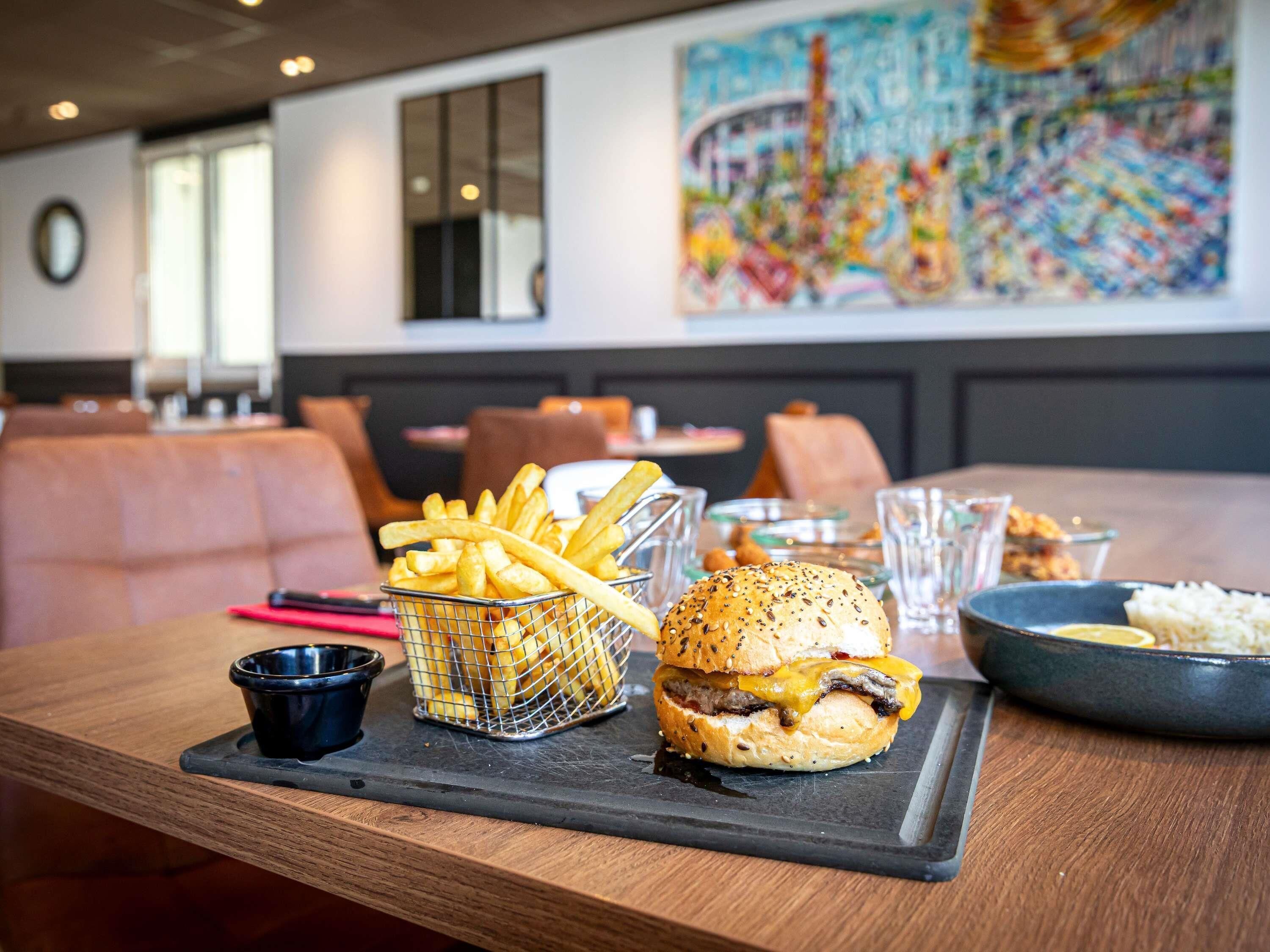 Une table à manger avec un hamburger, des frites et un bol de riz.