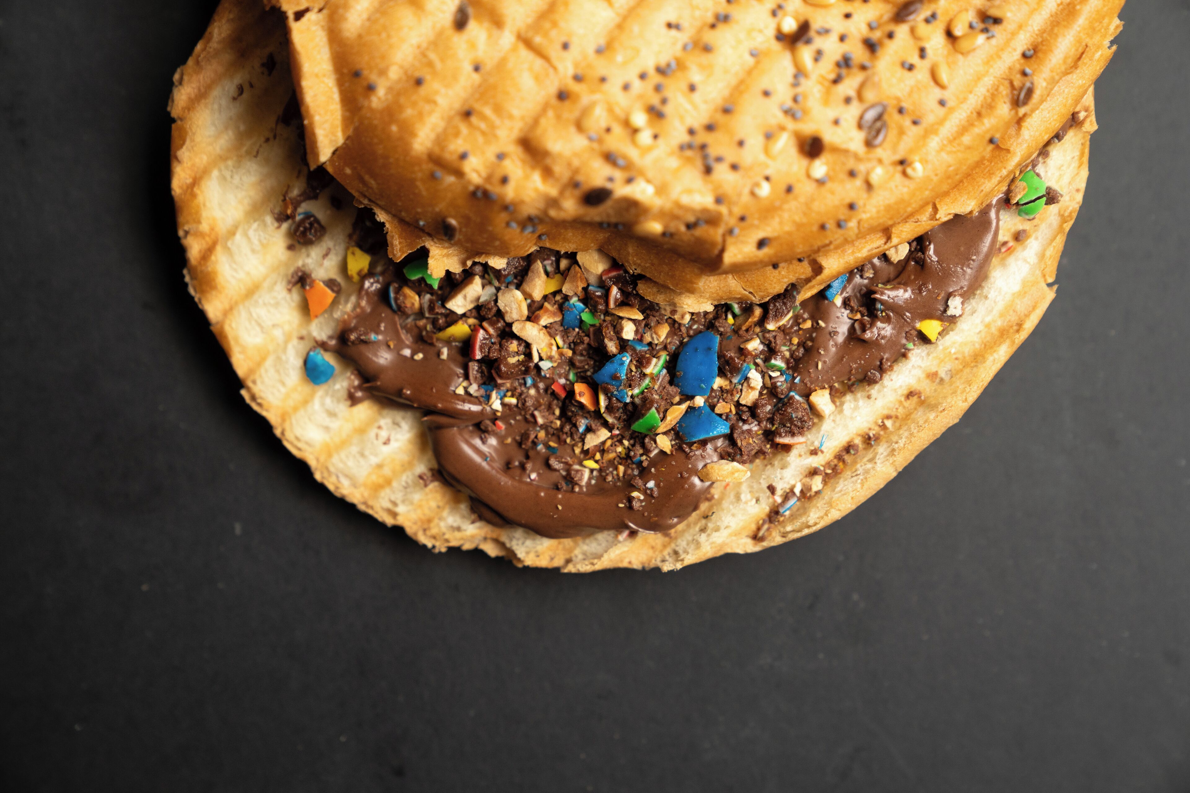 Un panino con crema al cioccolato e codette colorate.