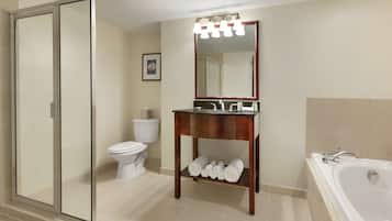 Un baño con ducha de vidrio, inodoro, lavabo con espejo y bañera.